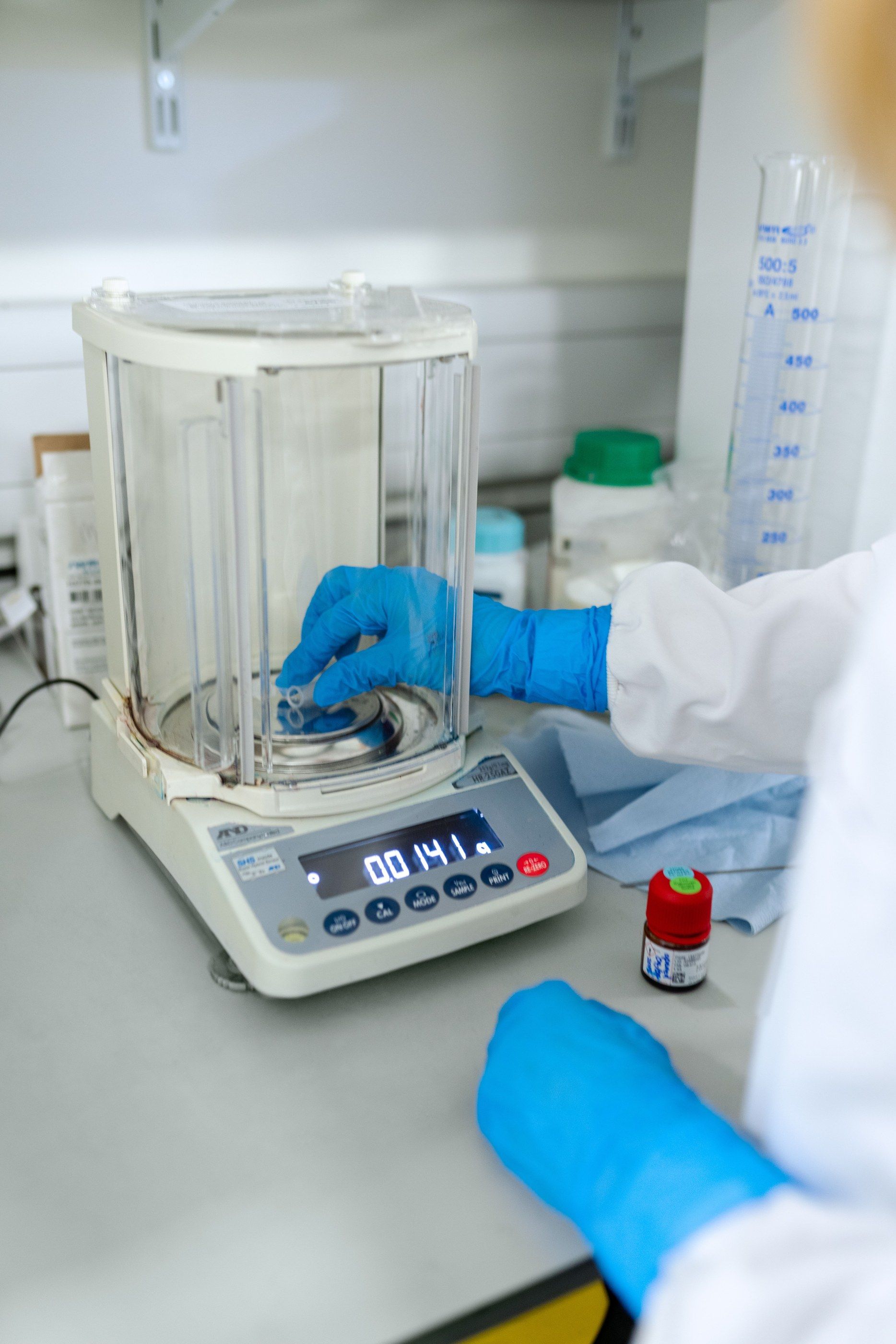 Precision balance and glassware on a laboratory bench
