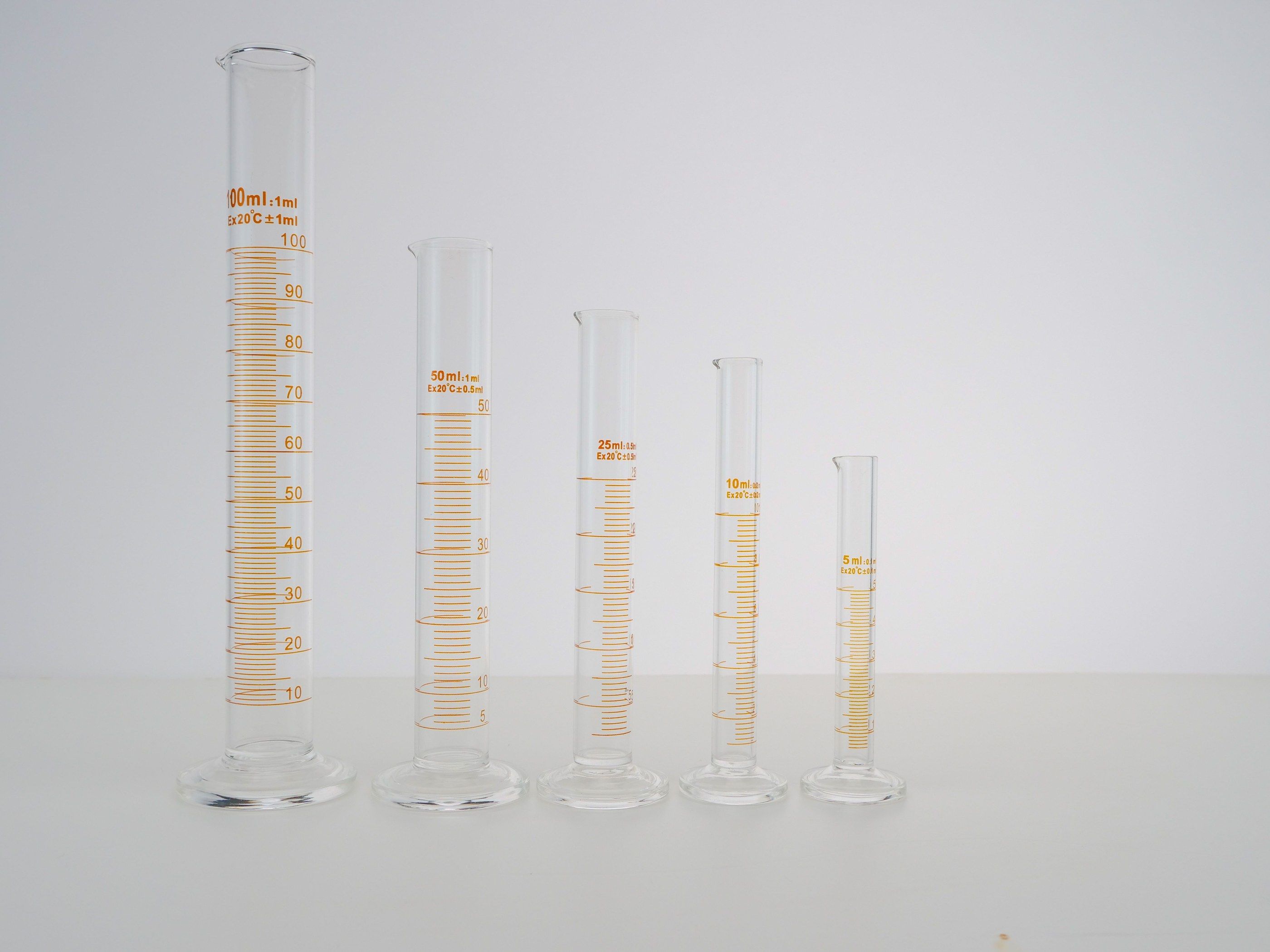 Graduated cylinders lined up on a light background