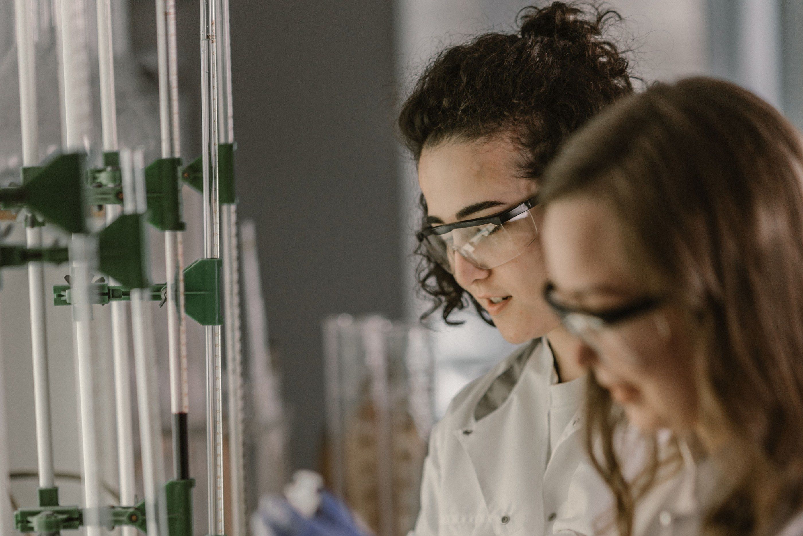 Two scientists looking at a glassware setup